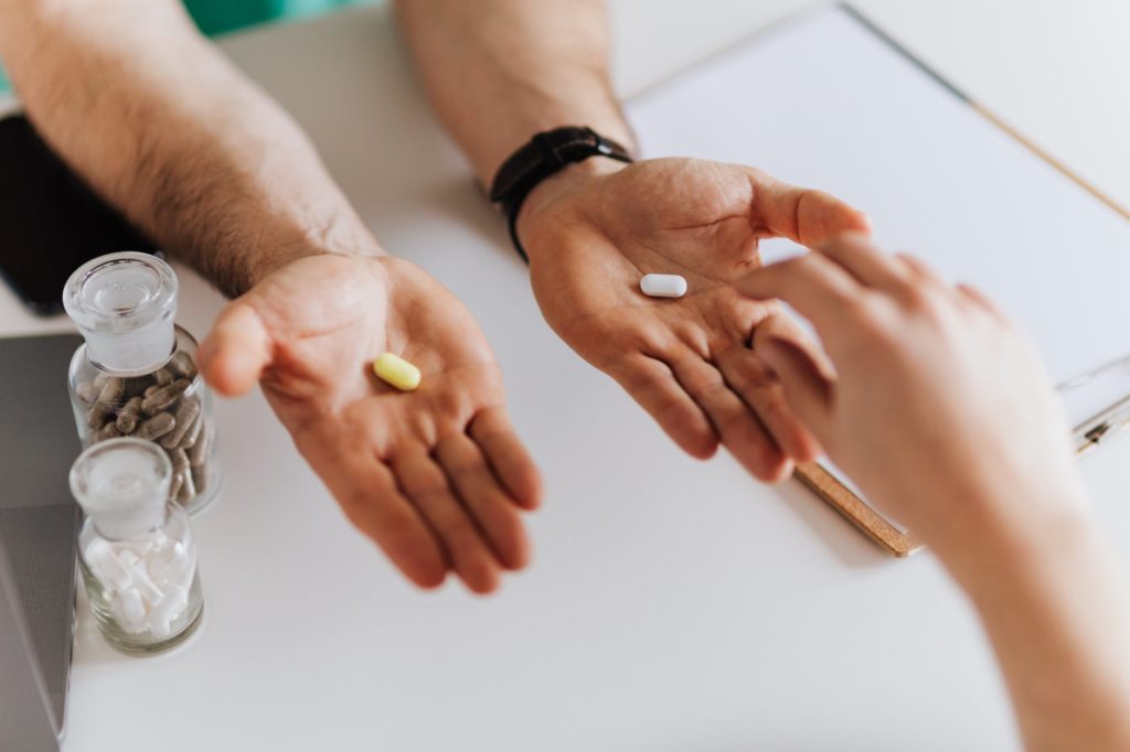 doctor giving pills to client in clinic