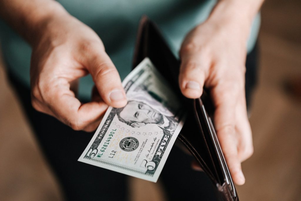 unrecognizable man holding wallet with money