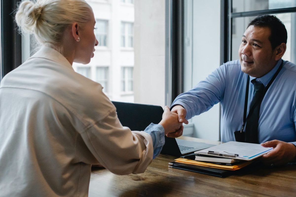 ethnic businessman shaking hand of applicant in office